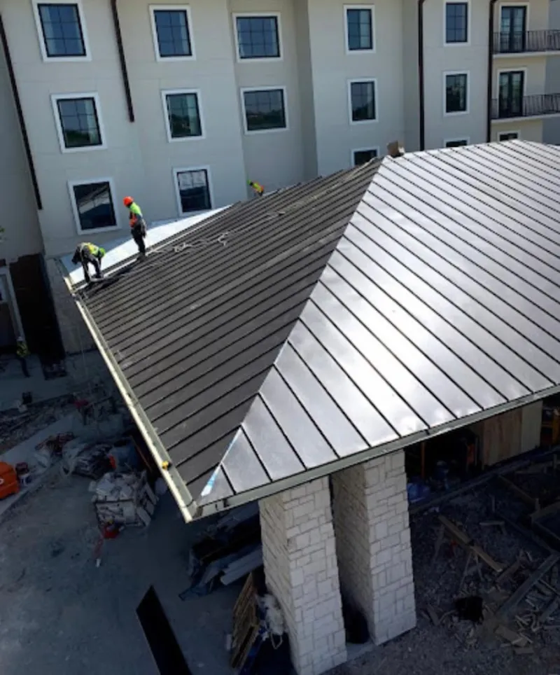 Crew installing standing seam metal roof panels on a commercial project in Camino Tassajara